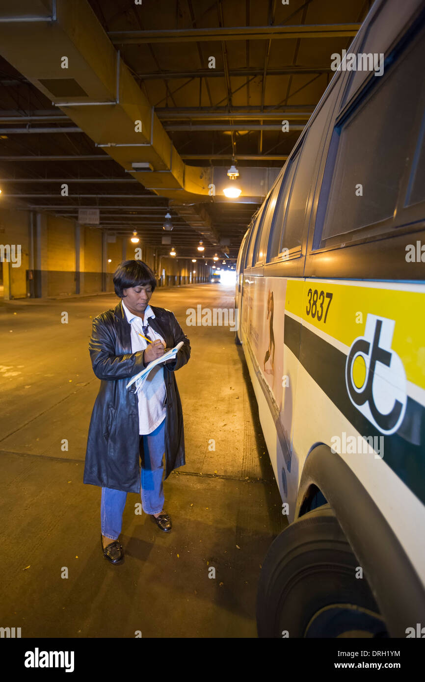 Un lavoratore controlli sulla condizione di autobus urbani a Detroit il terminal degli autobus. Foto Stock