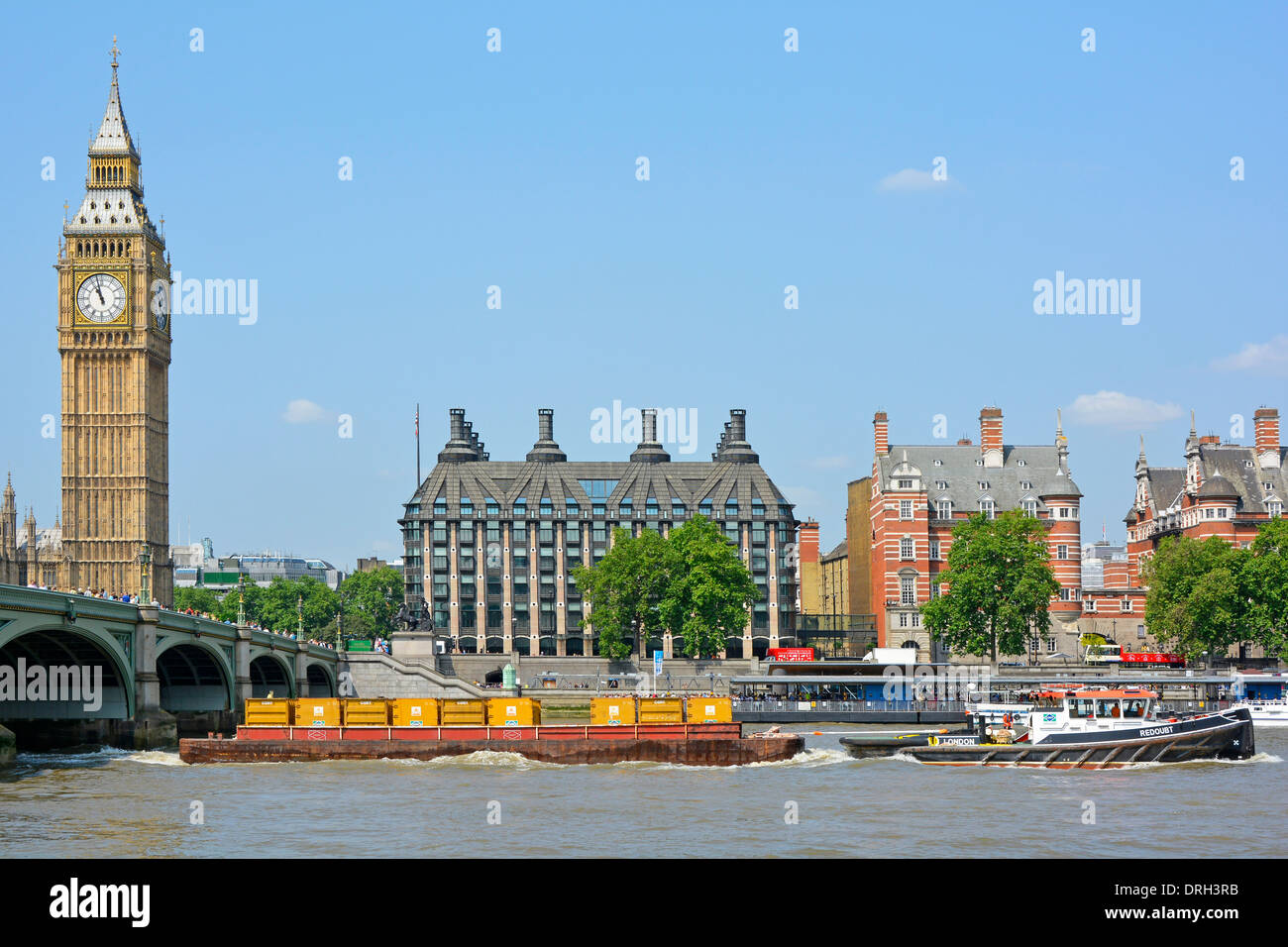 Rimorchiatore tirando barge caricato con i contenitori pieni di immondizia Londons passando Westminster Foto Stock