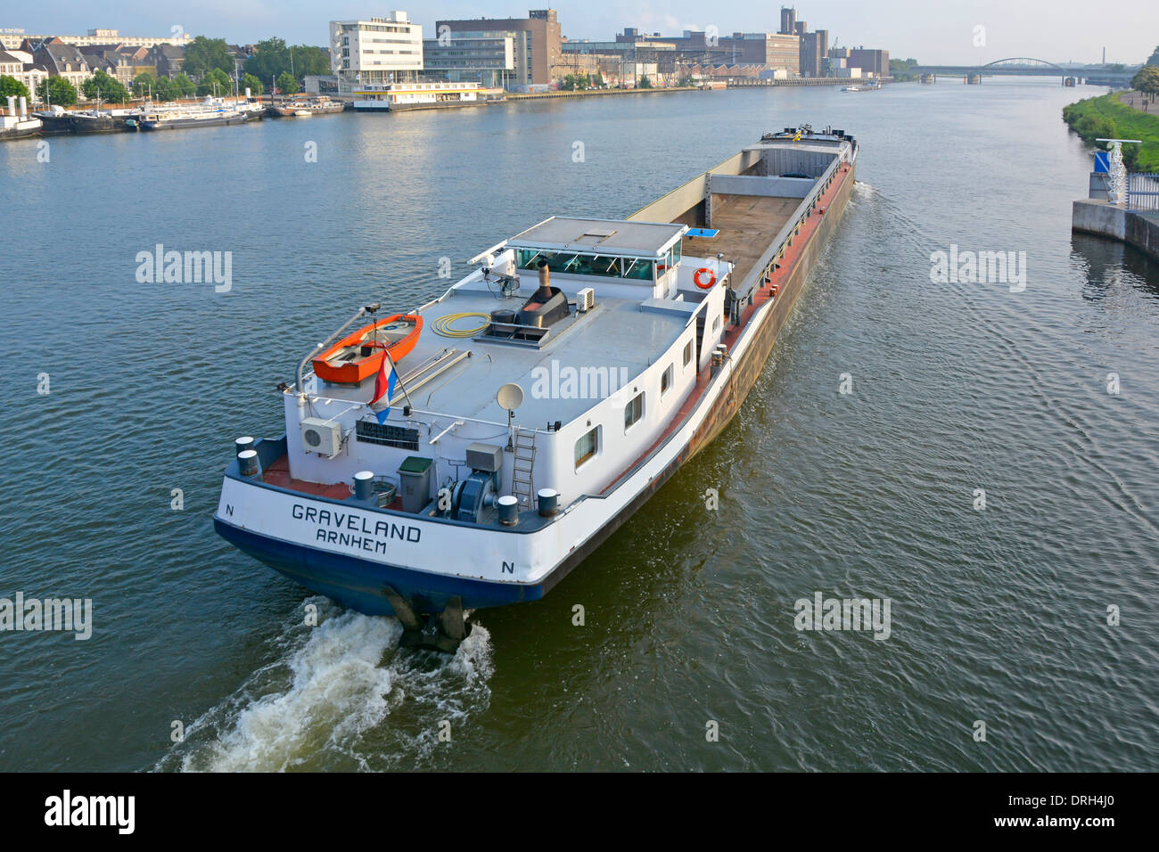 Maastricht Limburg vista dall'alto calma fiume Mosa (fiume Maas) lunga chiatta a motore per navi portarinfuse vuota che passa lungo il paesaggio urbano nei Paesi Bassi dell'UE Foto Stock