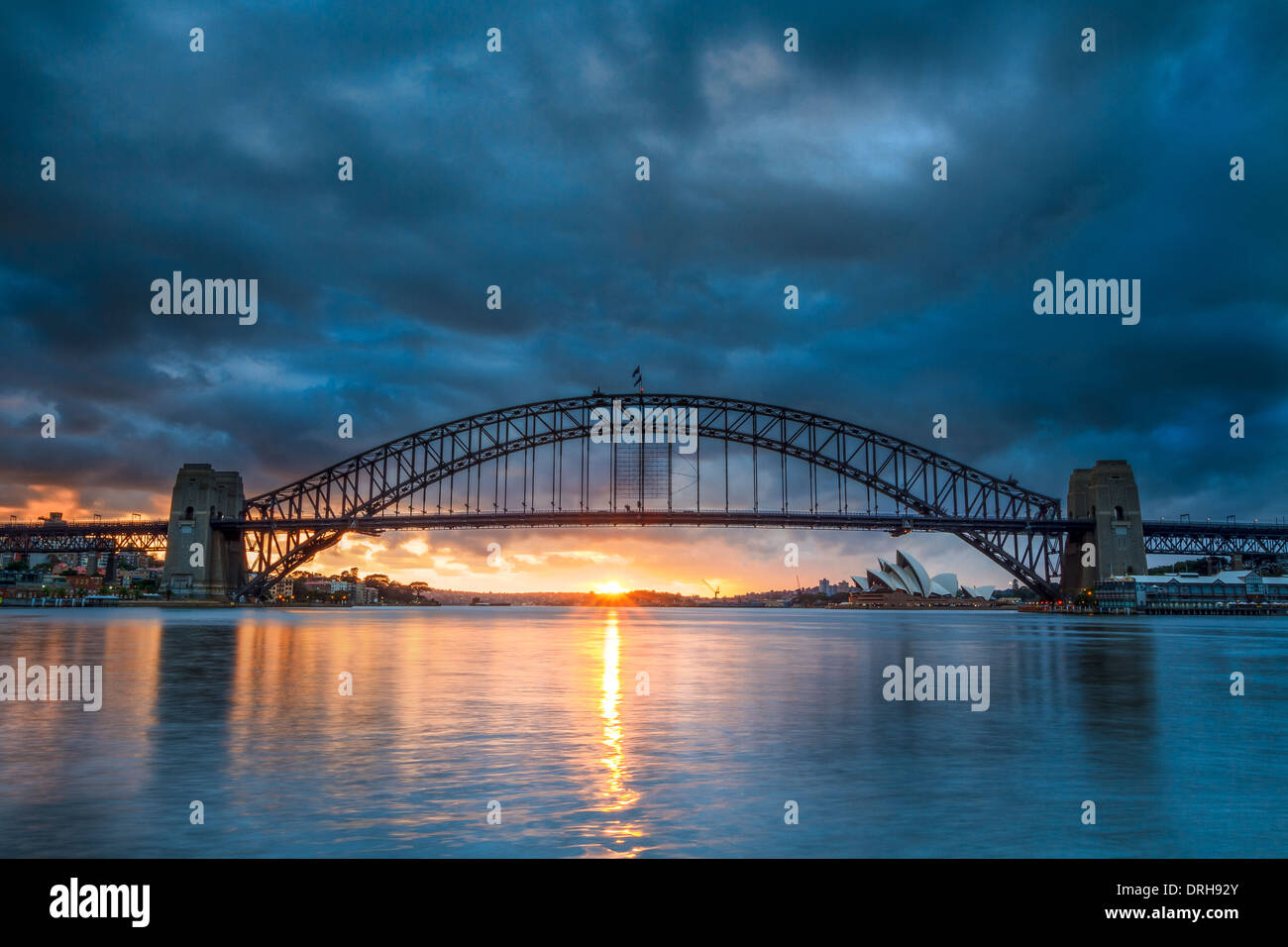 Il sole che sorge dietro il Ponte del Porto di Sydney in Australia il giorno, visto dal punto di Blues di riserva. Foto Stock