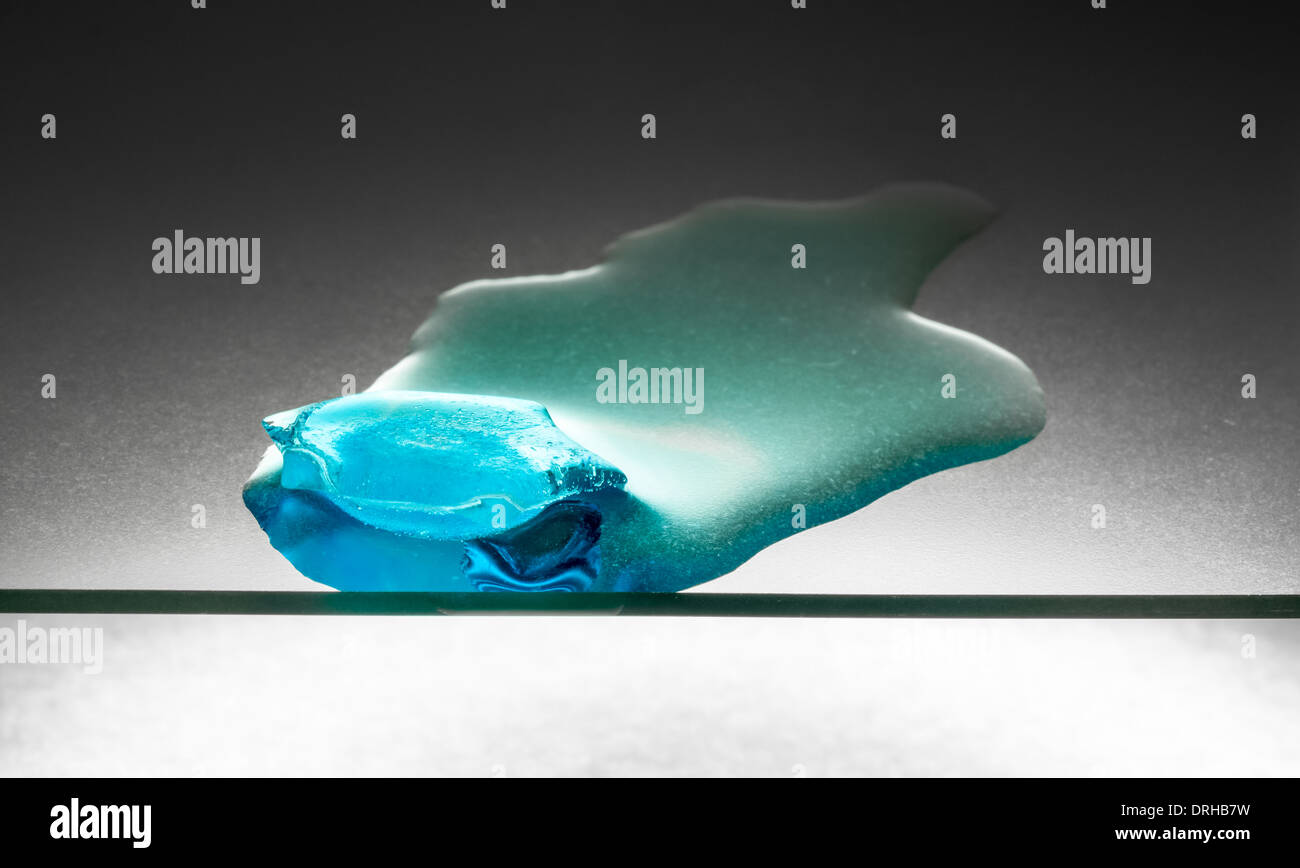 Blue pezzo di fusione del ghiaccio su una lastra di vetro Foto Stock