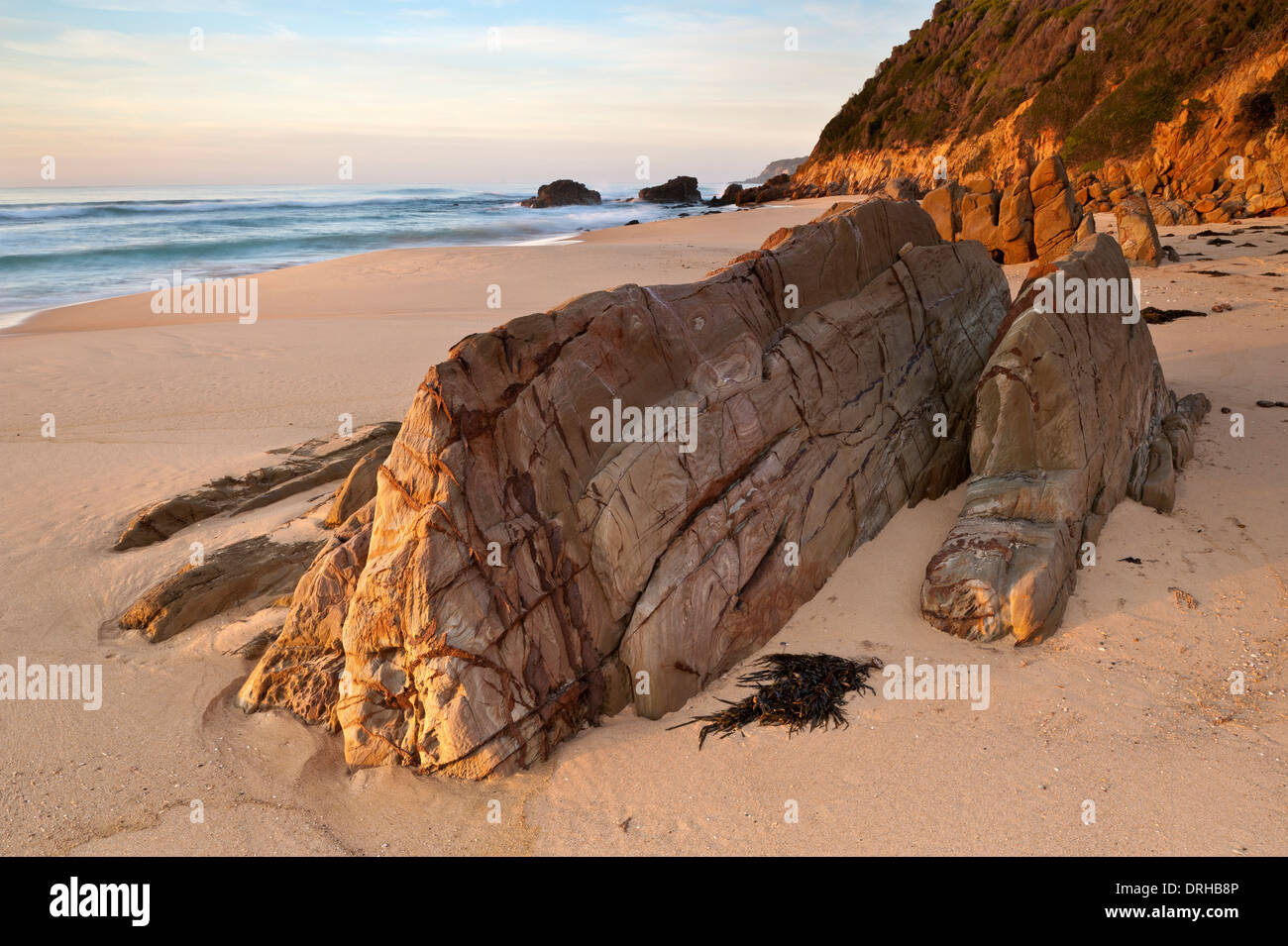 Sunrise sulla sabbia e rocce a Gillards Spiaggia La Mimosa Rocks National Park, New South Wales, Australia Foto Stock