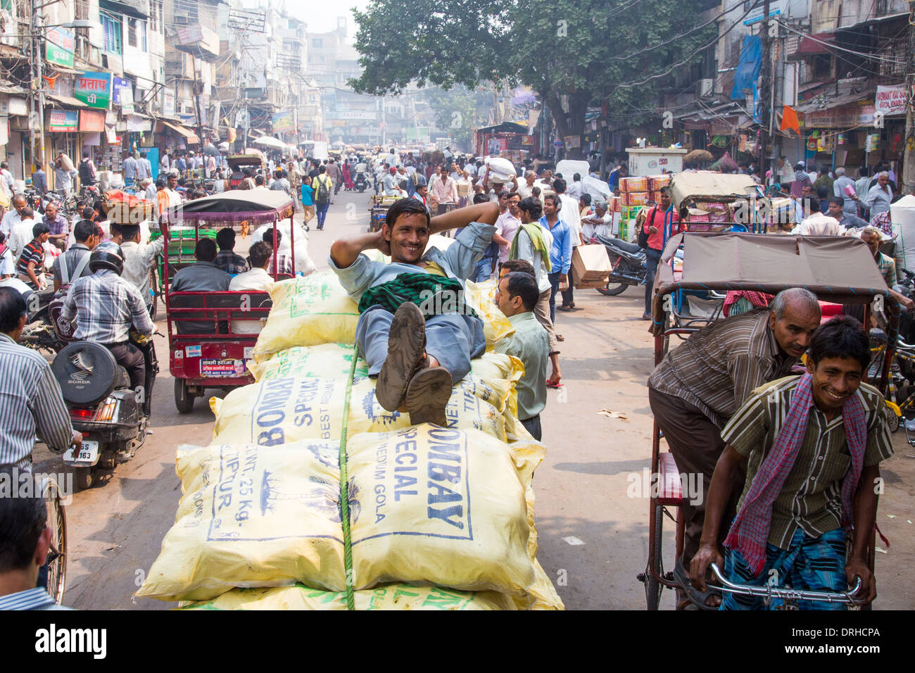 Porter in appoggio sui sacchi di spezie nel mercato delle spezie, la Vecchia Delhi India Foto Stock