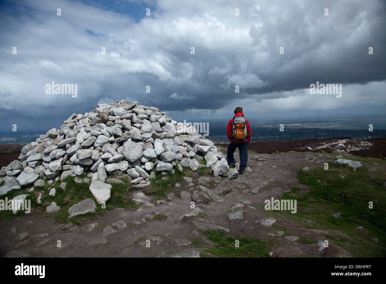 Escursionista accanto alla tomba neolitica di castello fiabesco, alla sommità di due Rock Mountain. Montagne di Dublino, nella contea di Dublino, Irlanda. Foto Stock