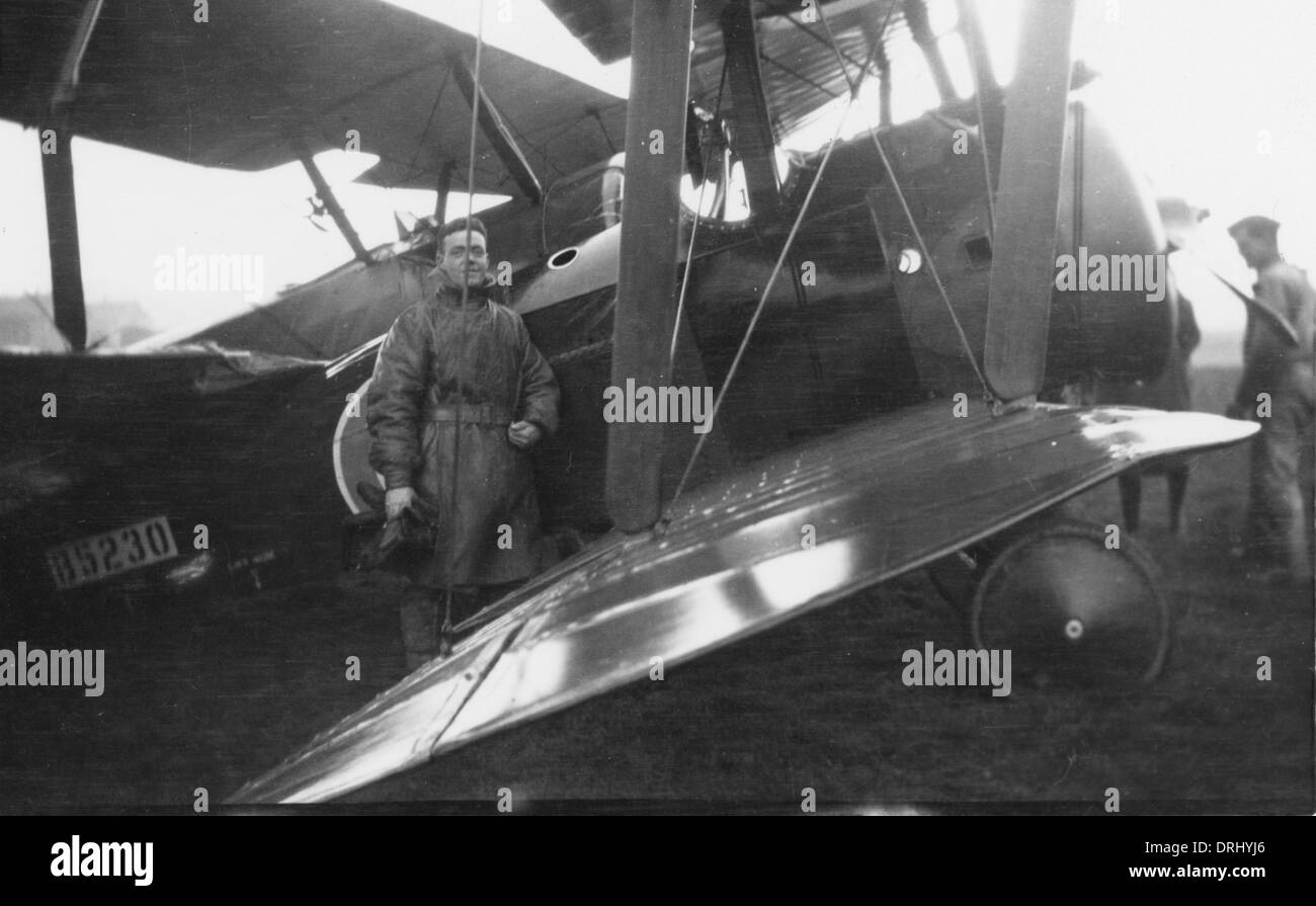Pilota in piedi con un biplano su un campo di aviazione, WW1 Foto Stock