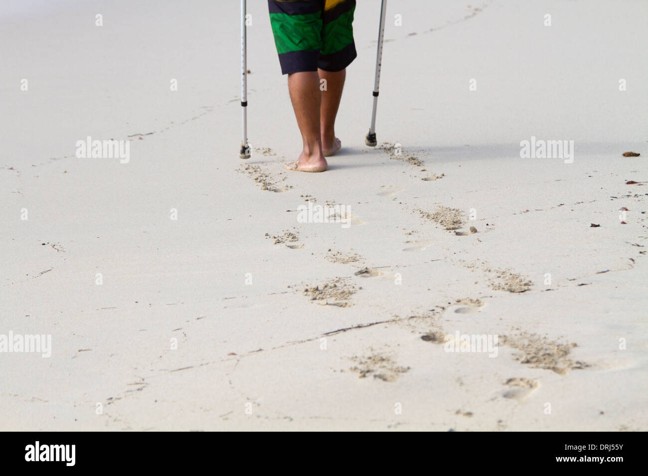 Camminare sulla spiaggia di sabbia con le stampelle Foto stock - Alamy