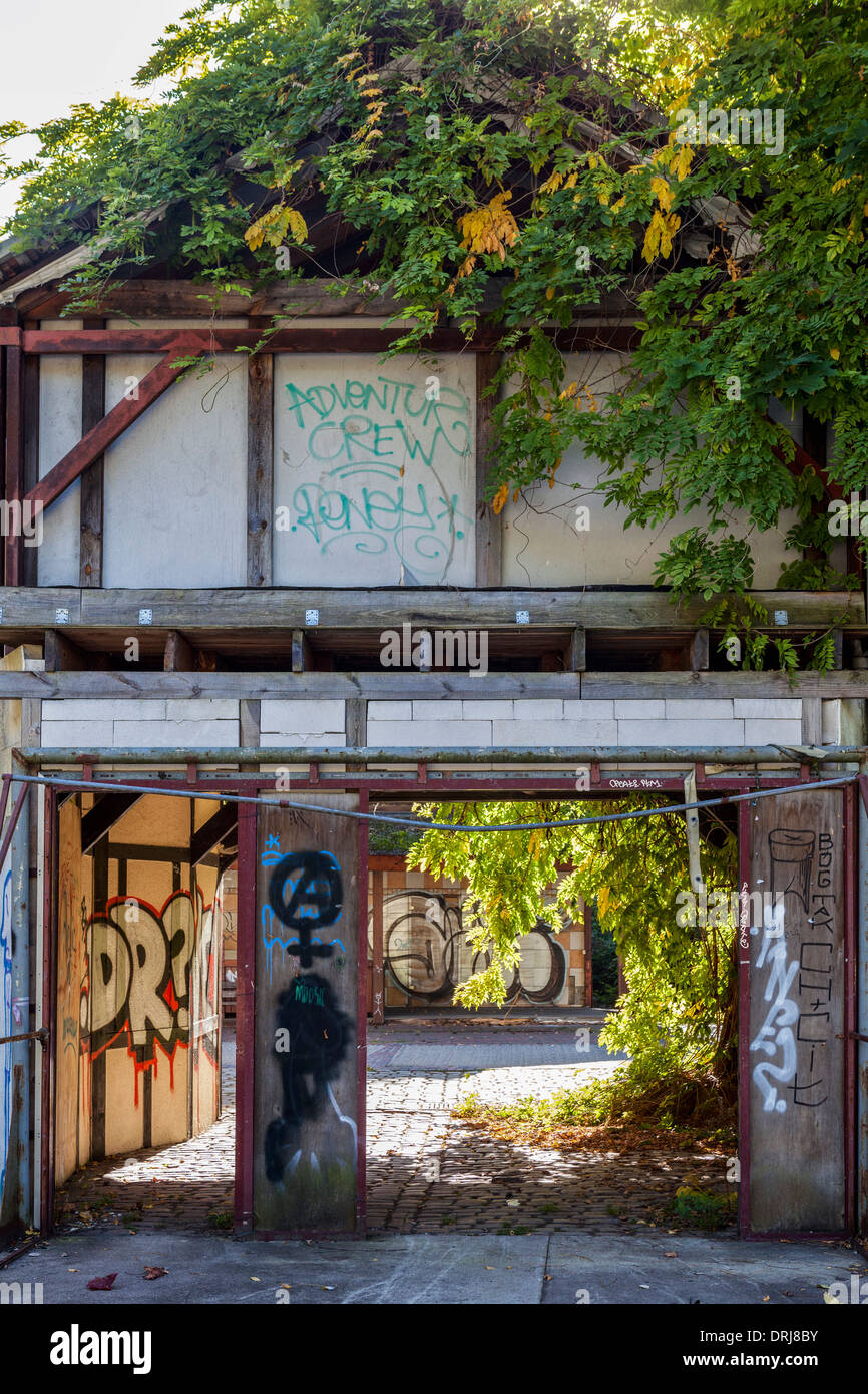 Danneggiato, superriduttore e coperto di graffiti, abbandonati villaggio inglese edificio, Spreepark, Plånterwald, Treptow-Kopernick, Berlino Foto Stock