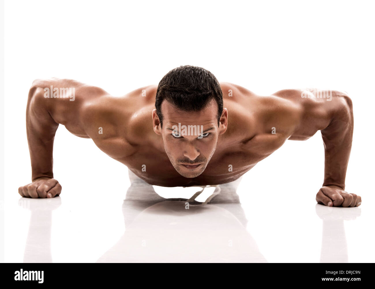Muscolo uomo rendendo ups push in studio, isolate su uno sfondo bianco Foto Stock