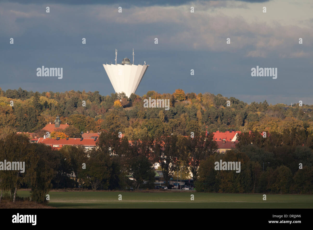 Vista di una città con una torre di acqua al tramonto Foto Stock