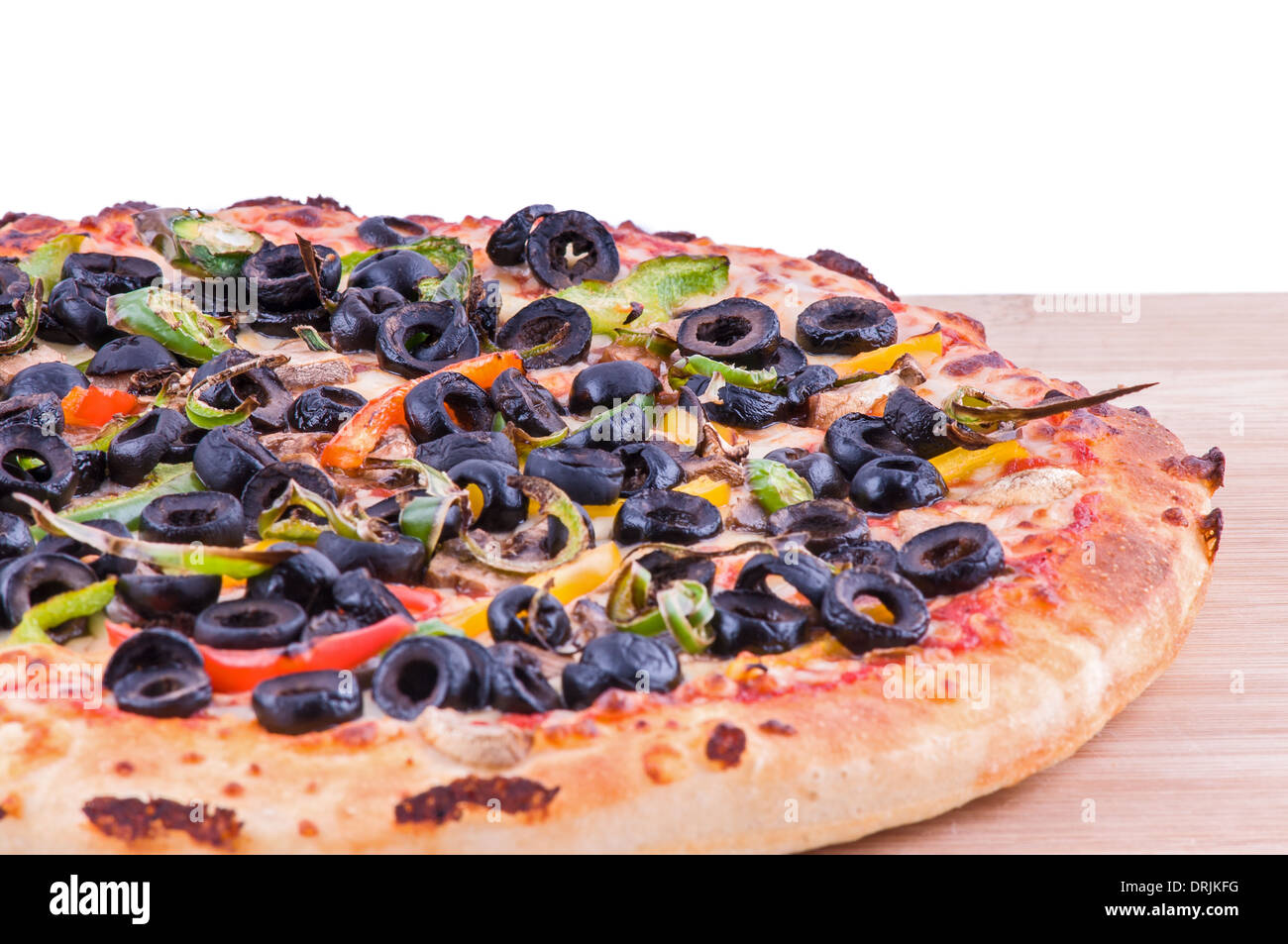 Tutta la pizza vegetariana su un tagliere, topping includono Olive Pomodori, pepe e formaggio Foto Stock