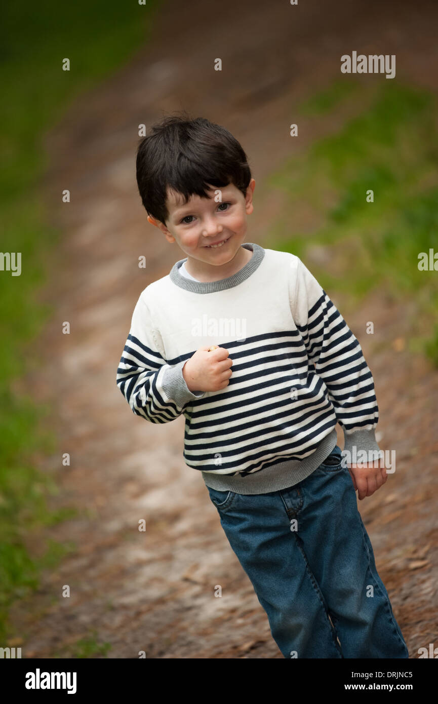 Ragazzo giovane modello all'aperto nella foresta e godere di stile di vita di età compresa tra i 4 Foto Stock