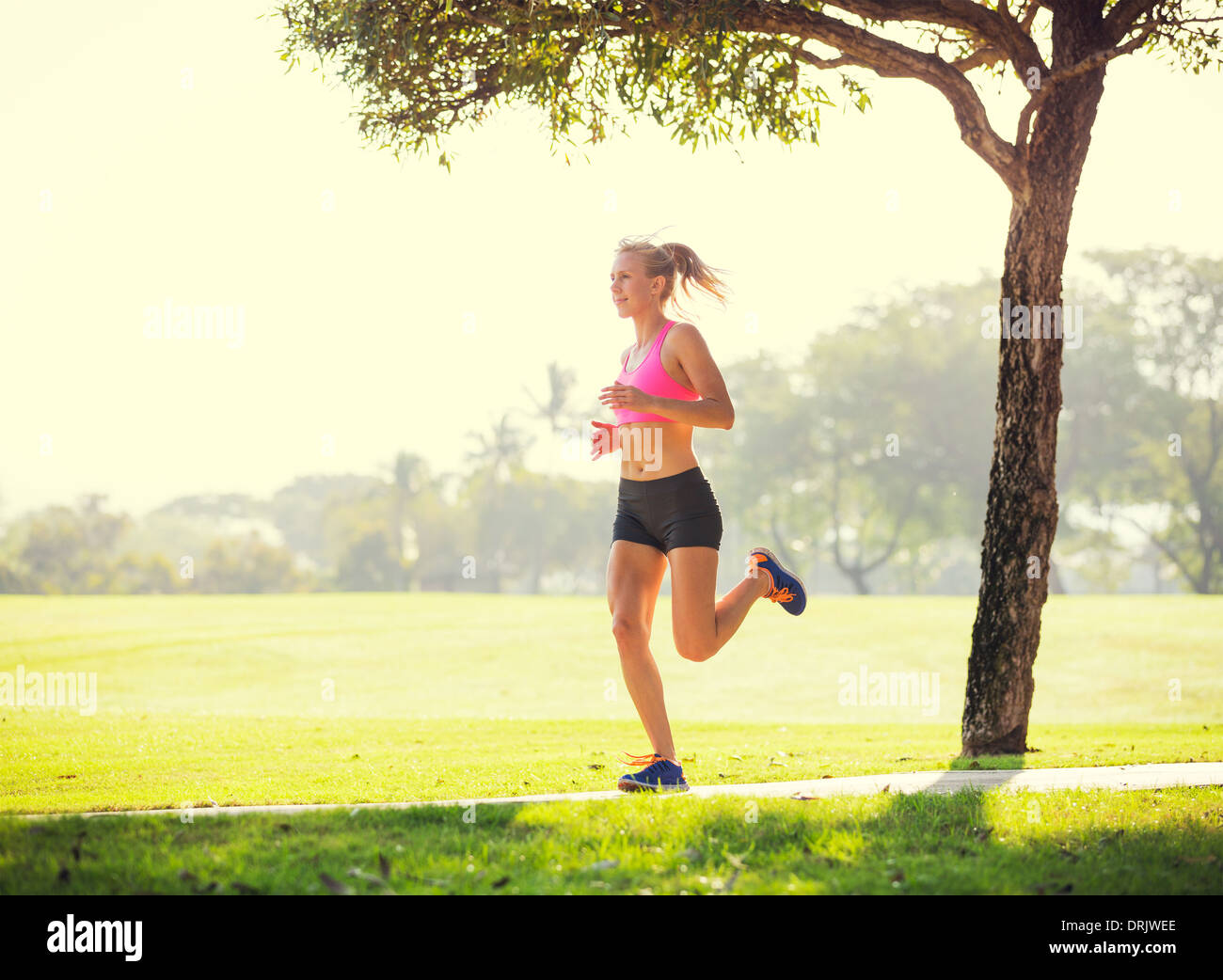 Montare Atletica Giovane donna percorso jogging all'aperto la mattina presto nel parco. Uno stile di vita sano sport concetto di fitness. Foto Stock