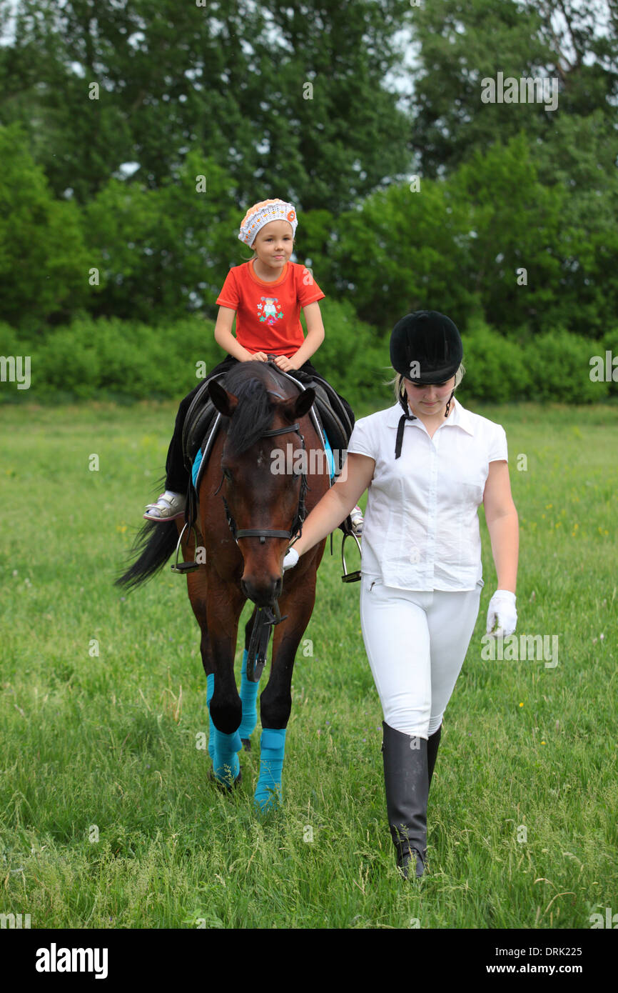 Ragazza equestre con la sua sorellina a cavallo Foto Stock