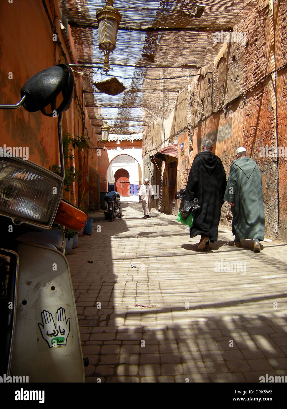 La Marrakechi andare circa le loro attività quotidiane in una scena di strada tipici di quella che si trova nella città di Medina a baldacchino, Marrakech, Foto Stock