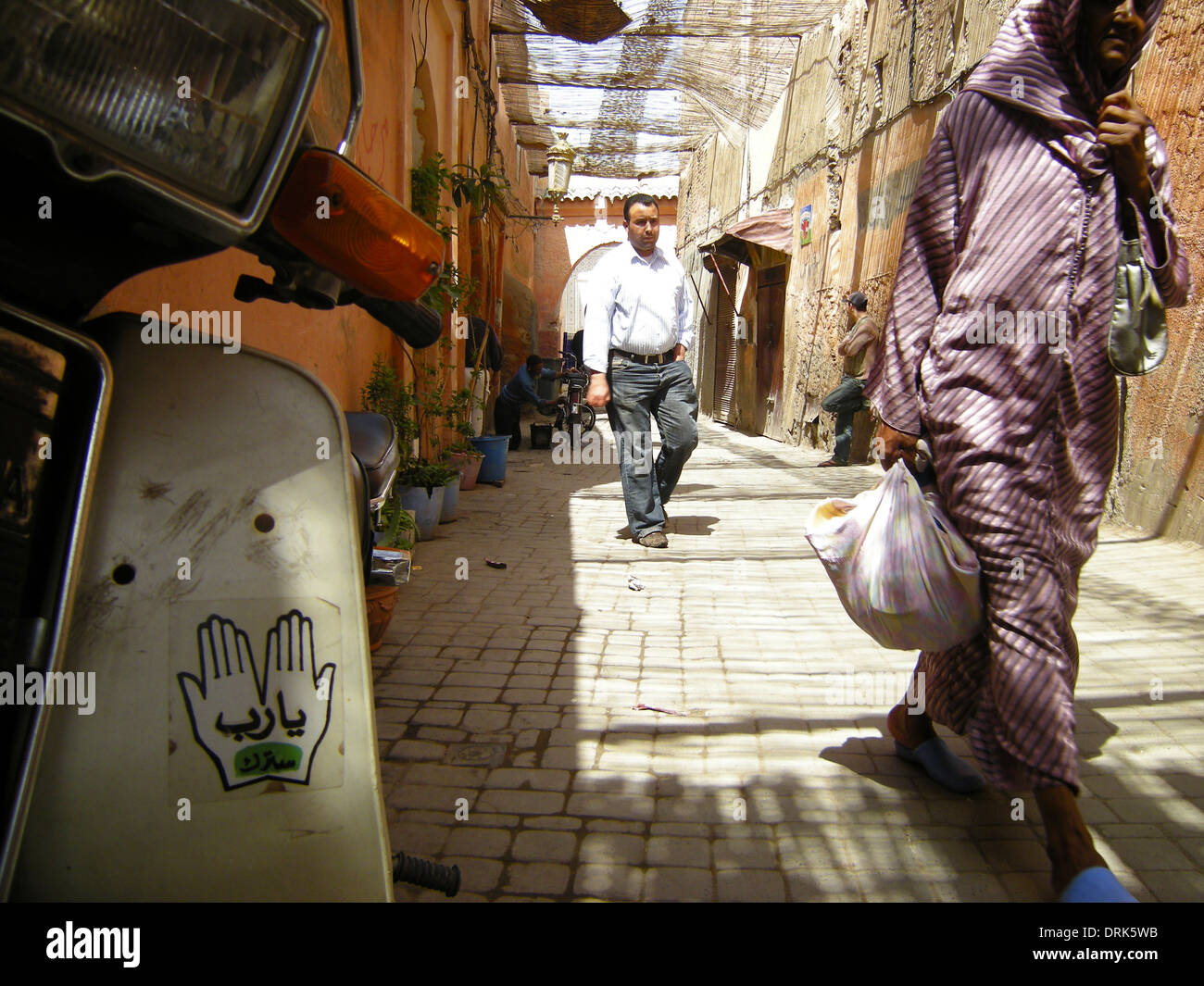 La Marrakechi andare circa le loro attività quotidiane in una scena di strada tipici di quella che si trova nella città di Medina a baldacchino, Marrakech, Foto Stock