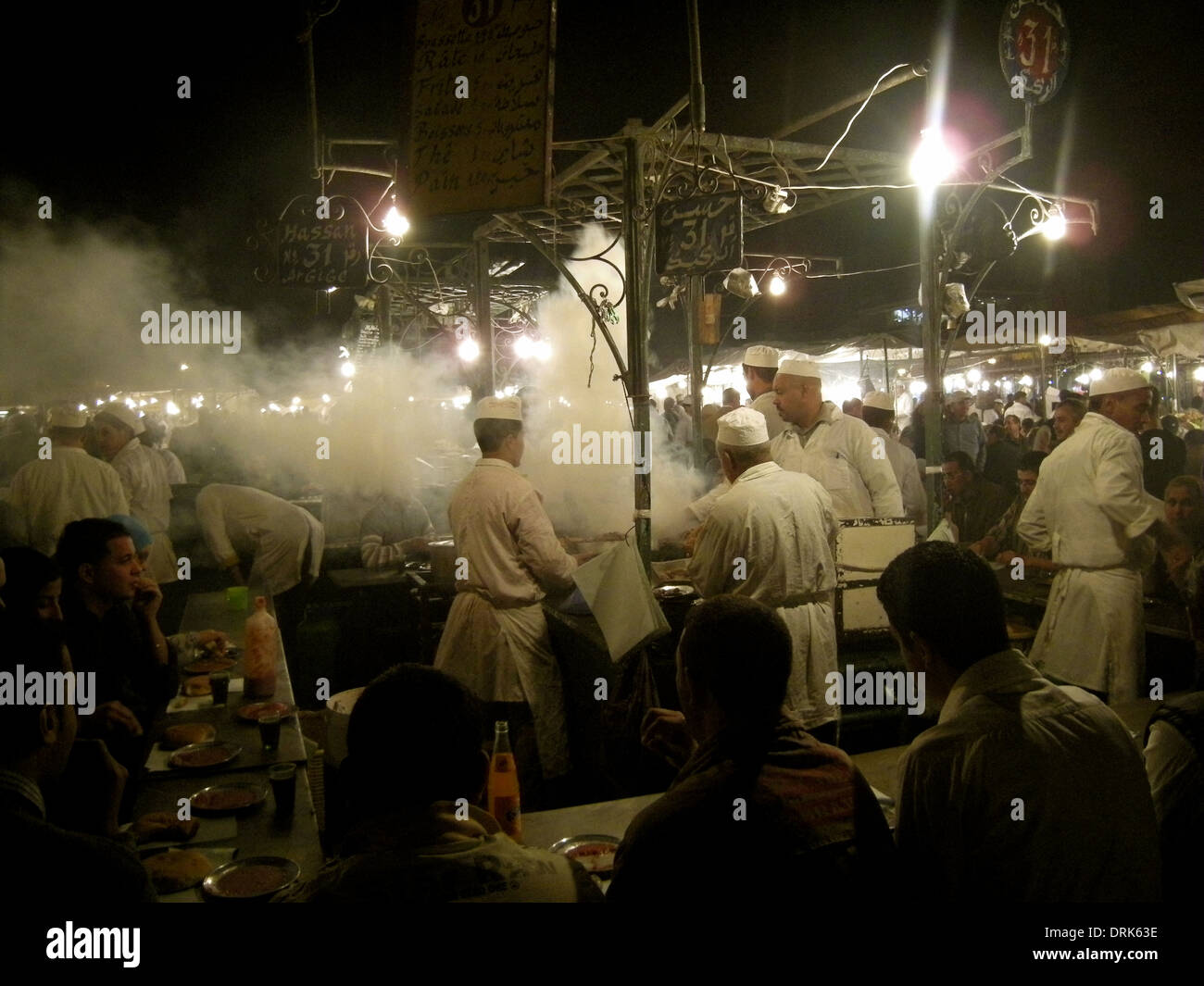 Grill volute di fumo intorno a chef all aria aperta stand gastronomici in piazza Jemaa el Fna di notte, Marrakech, Marocco Foto Stock