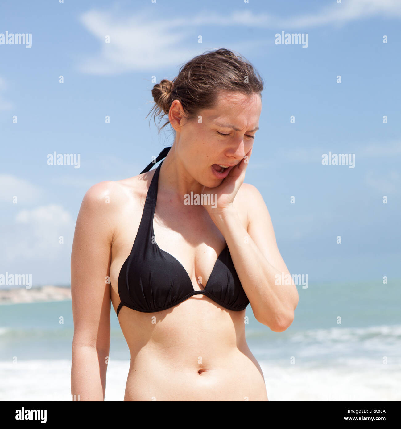 Donna con problemi di salute durante le vacanze sulla spiaggia Foto Stock