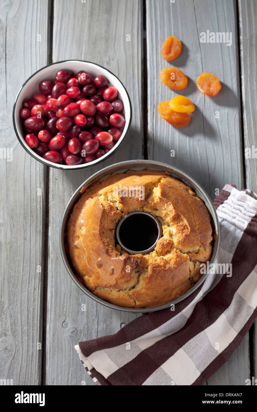 Tortiera con anello al forno torta, asciugatutto e freschi e frutta secca su grigio tavolo in legno Foto Stock
