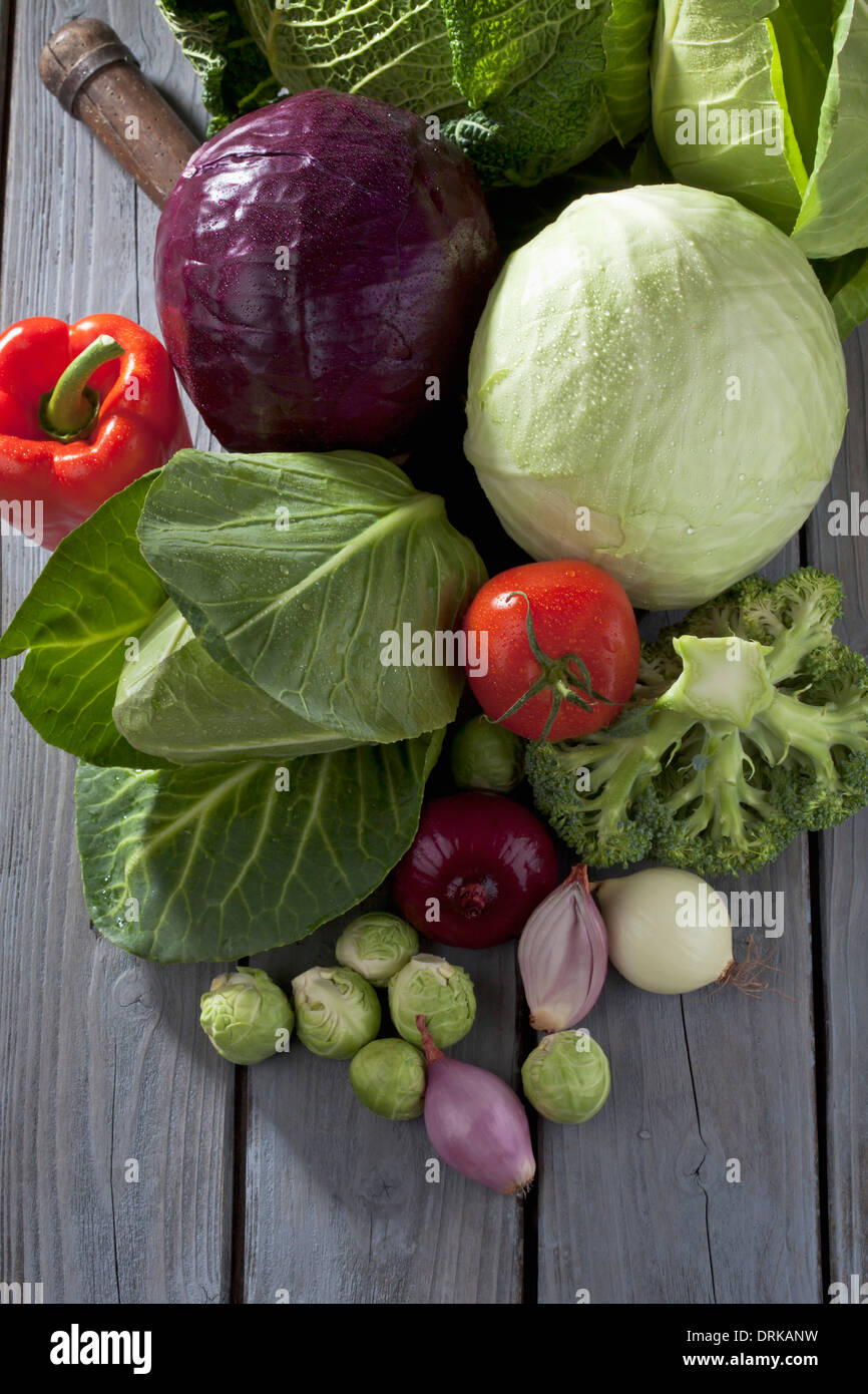 Varietà di cavolo e altre verdure su grigio tavolo in legno Foto Stock