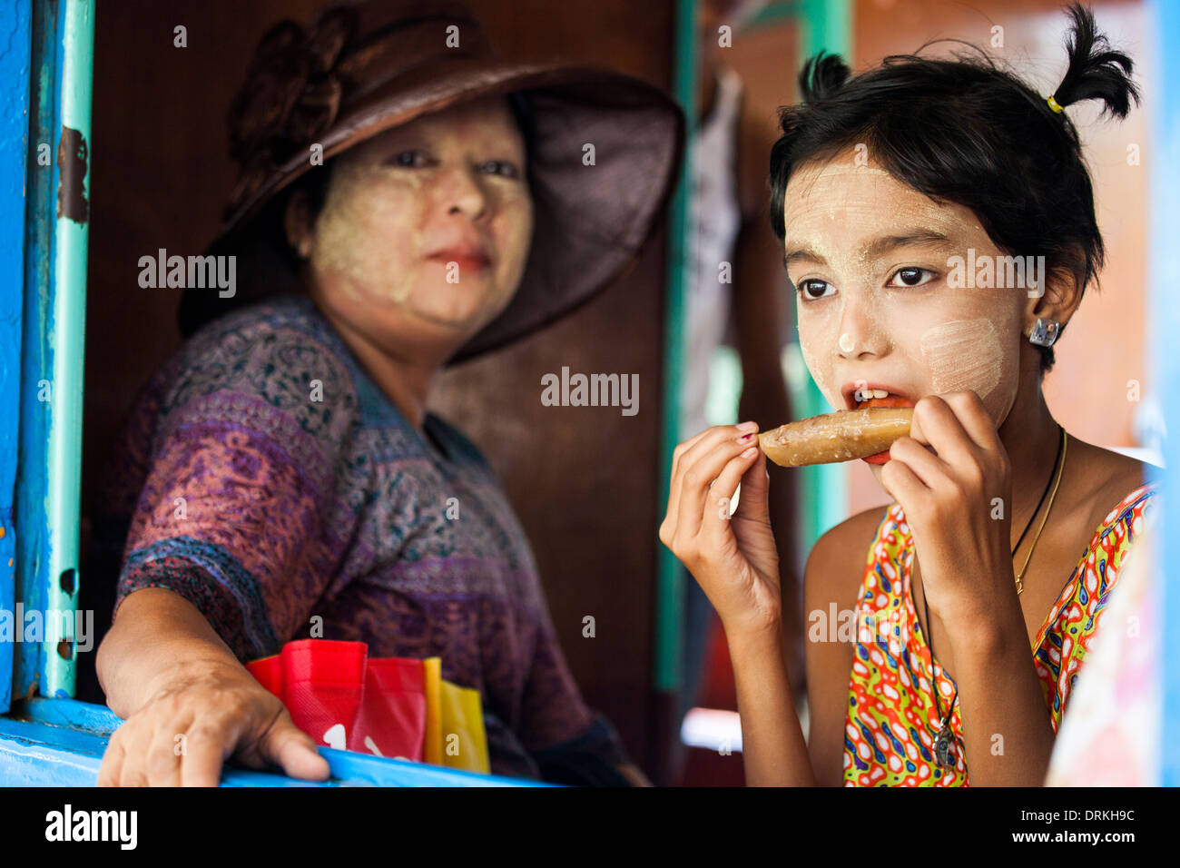 La ragazza e sua madre a cavallo di un treno a Yangon, Myanmar Foto Stock