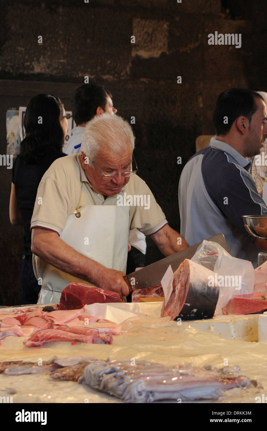 Venditori di pesce tagliare il pesce a la pescheria, catania mercato del pesce, Sicilia Foto Stock