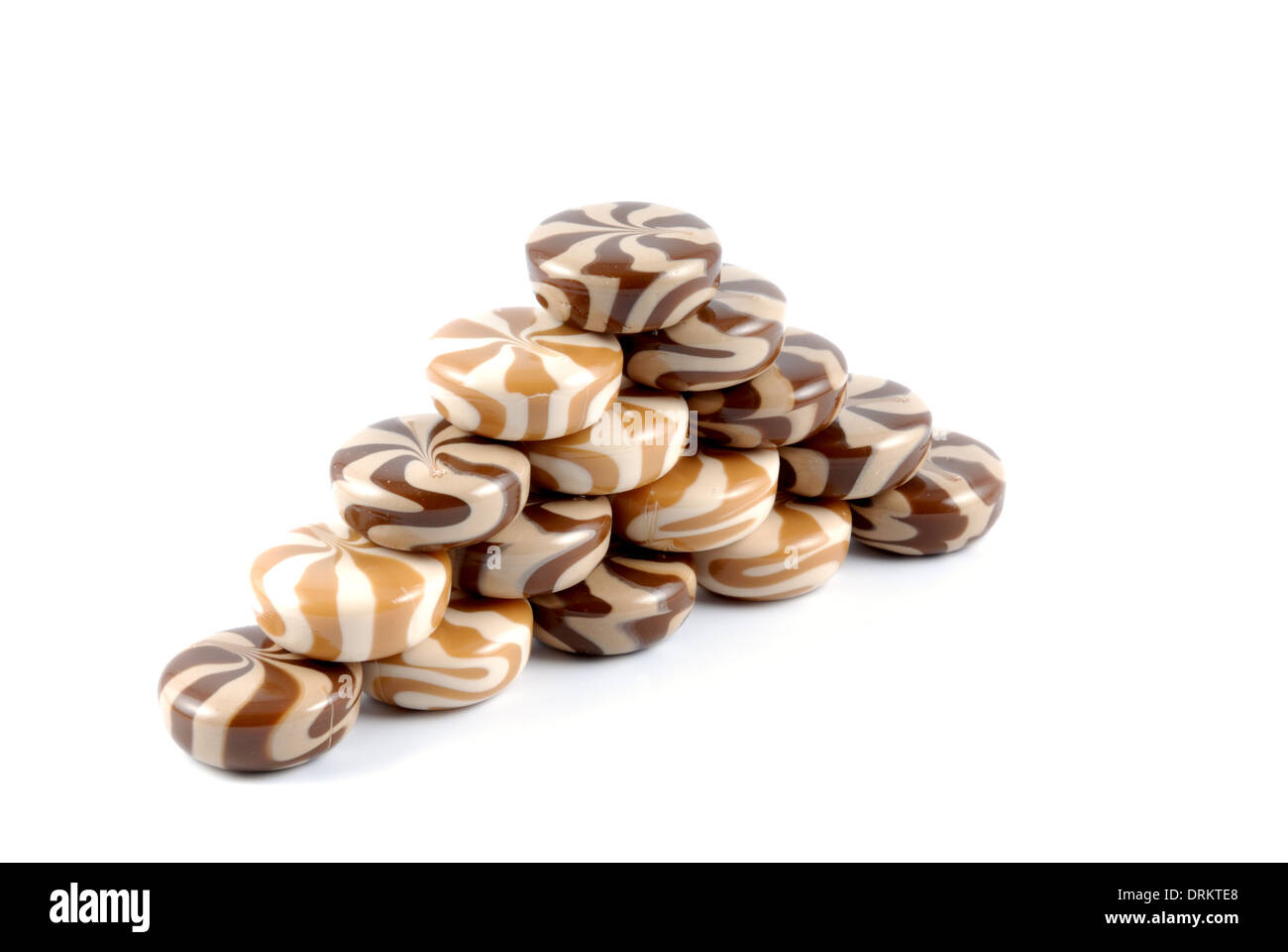 Il cioccolato cremosa di dolci caramelle di zucchero stabilite da una collina su uno sfondo bianco Foto Stock