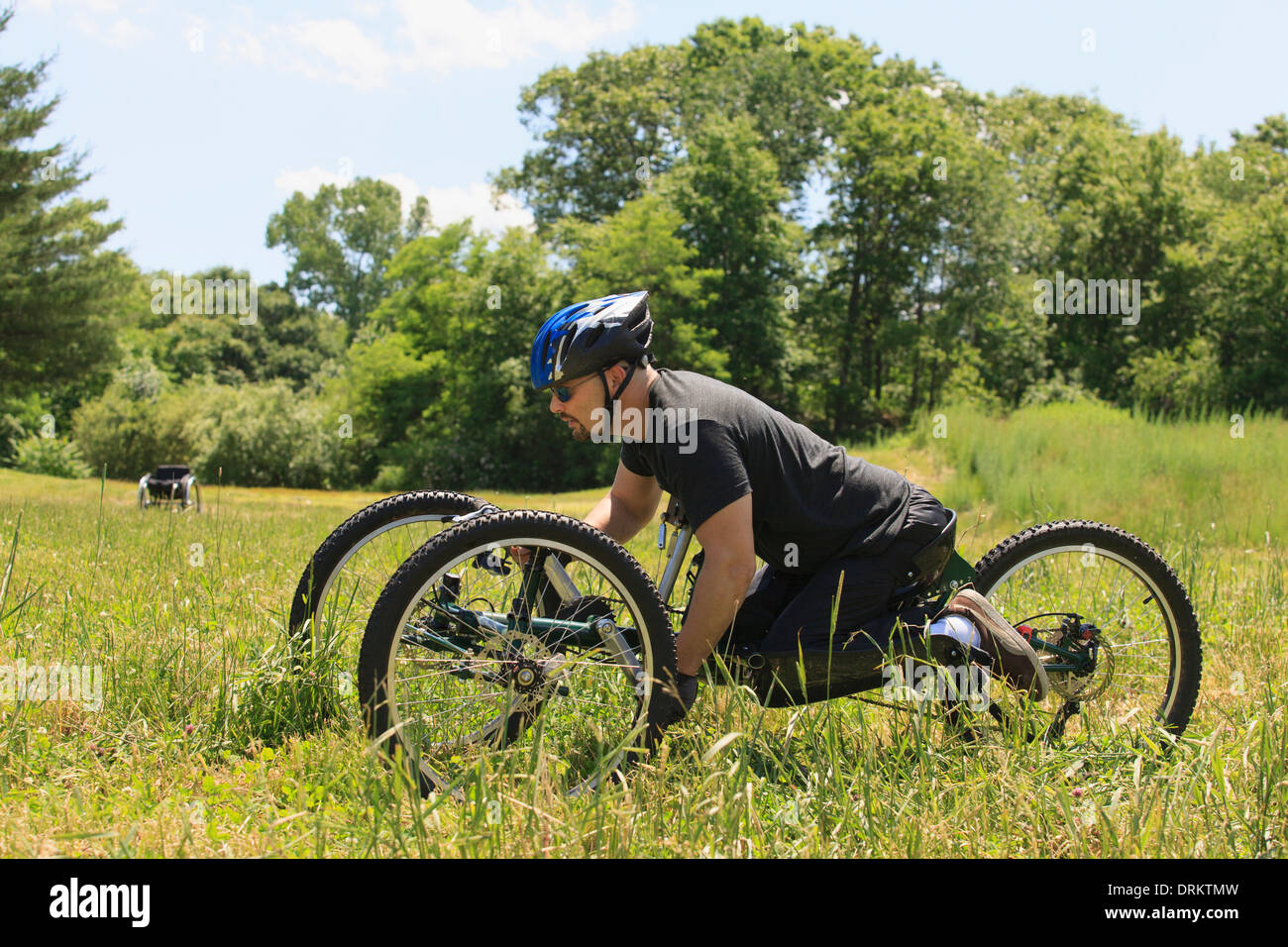 Uomo con lesioni del midollo spinale a cavallo su off-road ciclo a mano Foto Stock