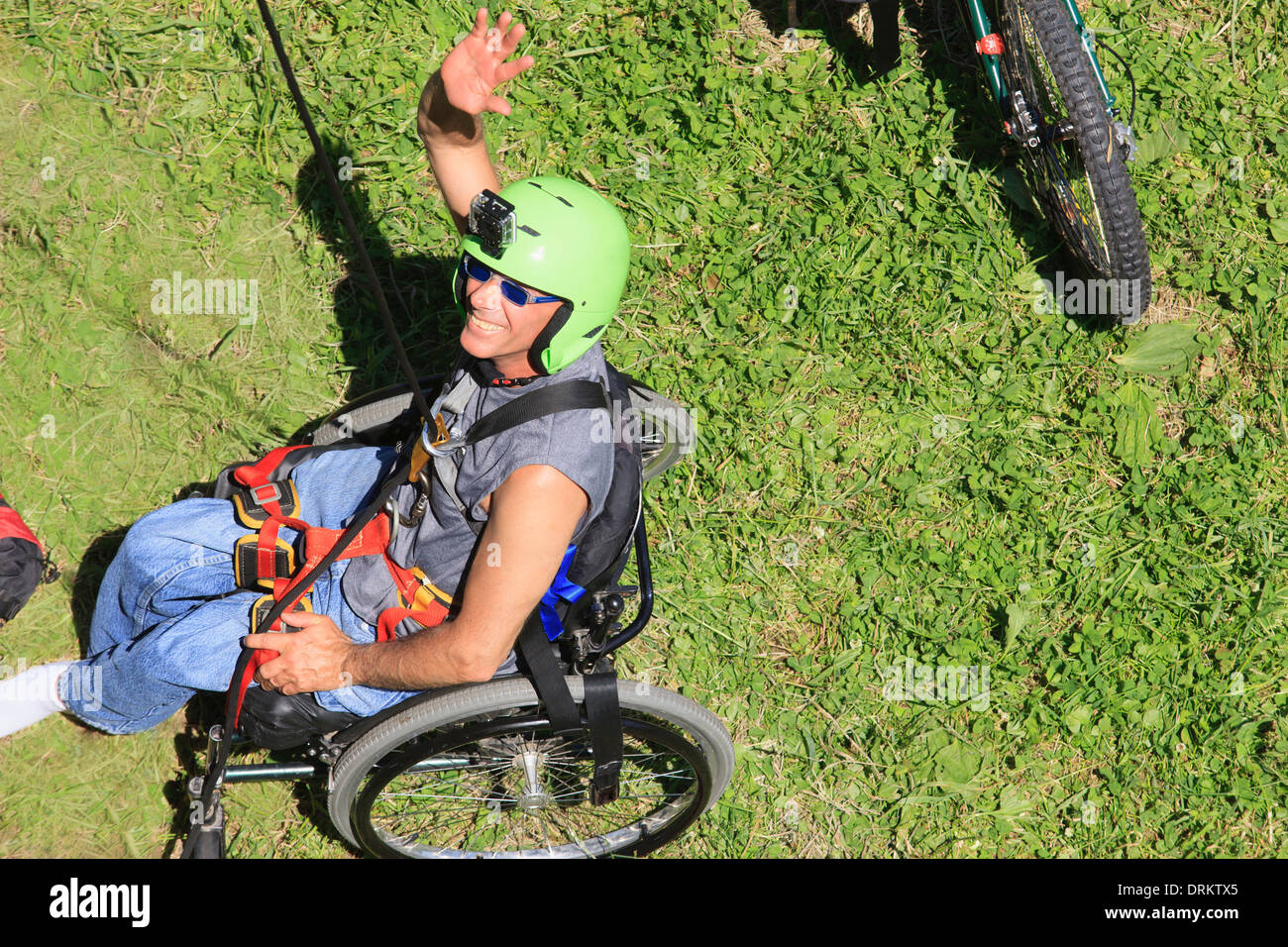 Uomo con lesioni del midollo spinale seduto in una sedia a rotelle la preparazione per la palestra di roccia Foto Stock