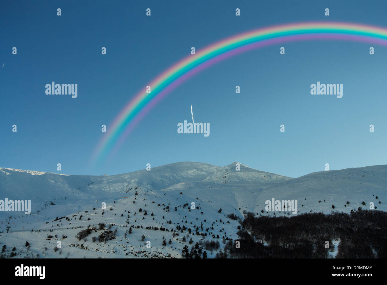 Rainbow nel bel mezzo delle montagne innevate Foto Stock