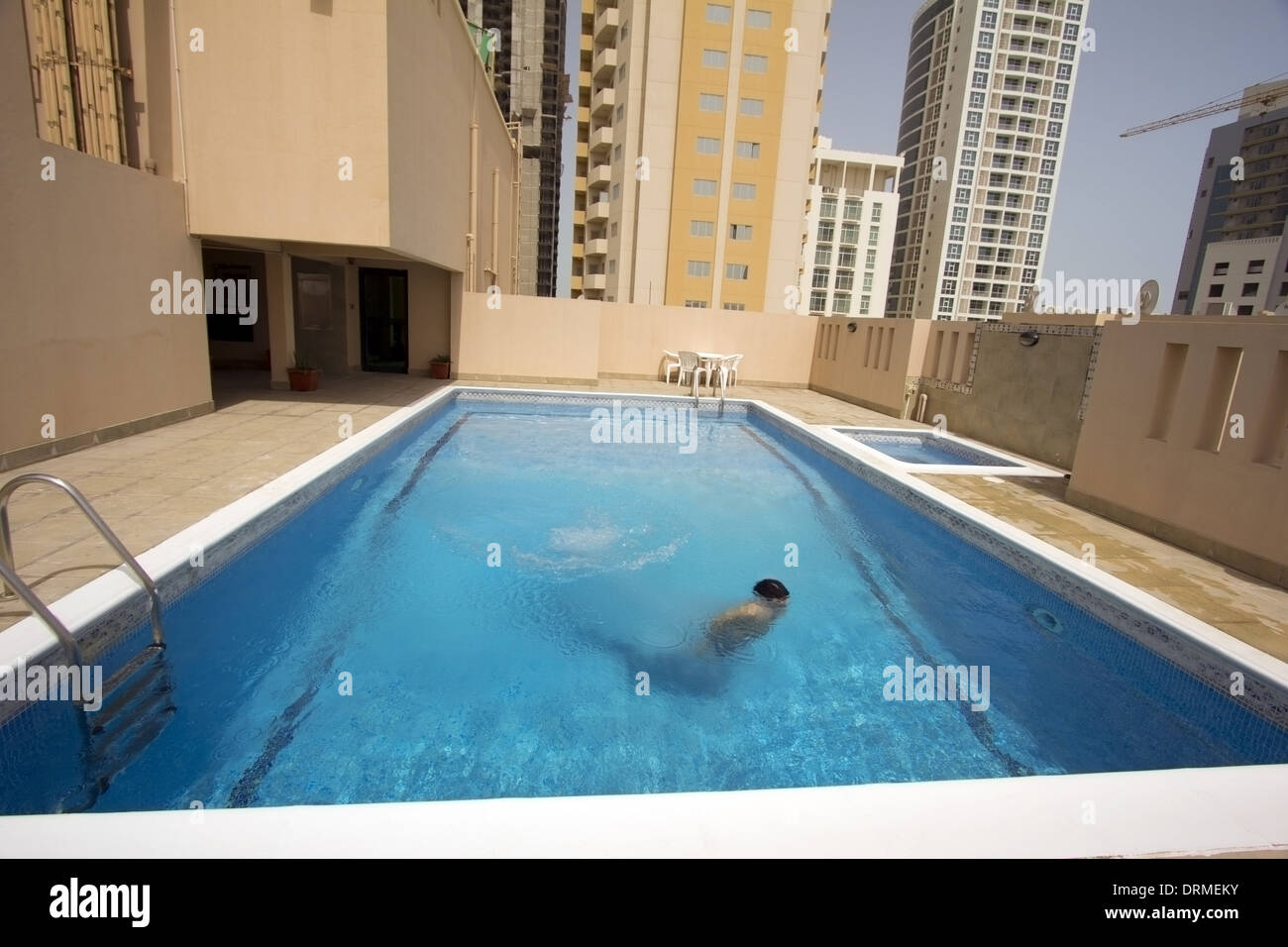 L'uomo nuotare nella piscina sul tetto dell'appartamento, Bahrain Foto Stock