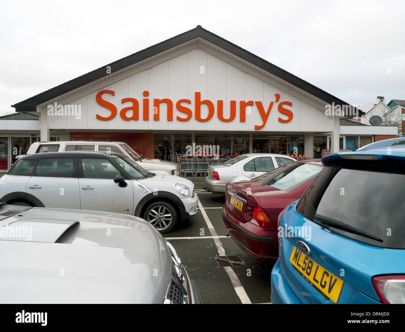 Vista esterna del Sainsbury's supermercato segno e auto nel parcheggio auto parcheggio Lampeter Wales UK KATHY DEWITT Foto Stock