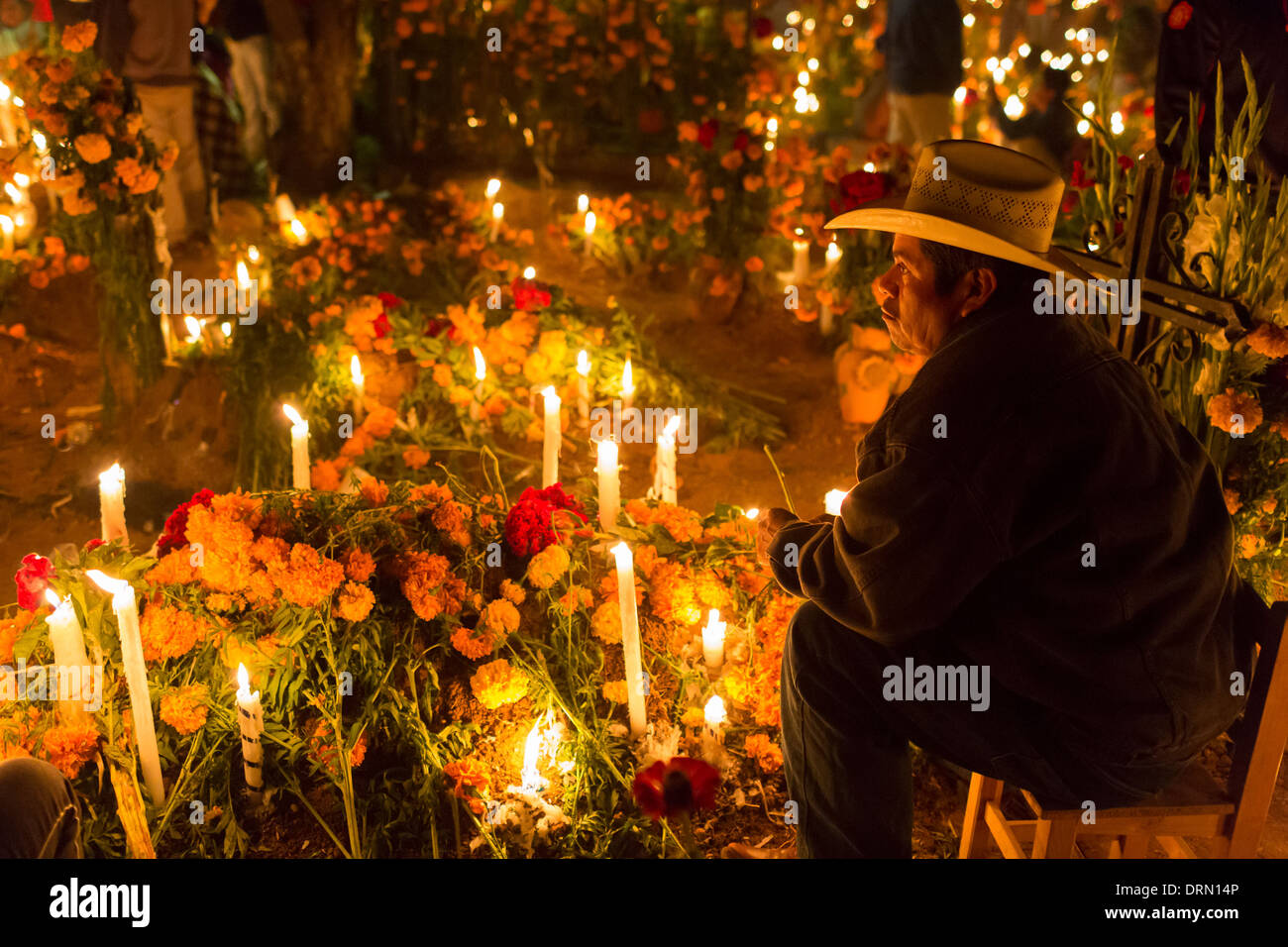 Un uomo trascorre la notte che accompagna la tomba di uno dei loro parenti morti. Foto Stock