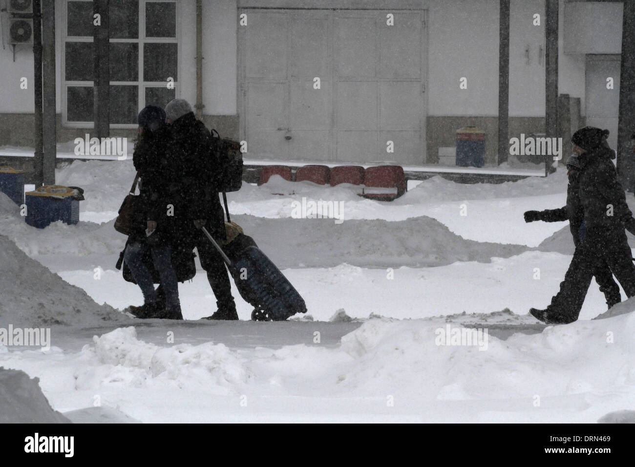 Bucarest, Romania. 29 gen 2014. Passeggeri a piedi nella neve presso la principale stazione ferroviaria di Bucarest, la capitale della Romania, 29 gennaio, 2014. Un nuovo forte tempesta di neve Mercoledì ha cominciato a colpire il Capitale di Romania nonché del sud e del sud-est. le autorità rumene hanno dichiarato lo stato di emergenza in quattro contee di Ialomita, Calarasi, Constanta e Tulcea per consentire la risposta alla corrente tempesta di neve. Credito: Gabriel Petrescu/Xinhua/Alamy Live News Foto Stock