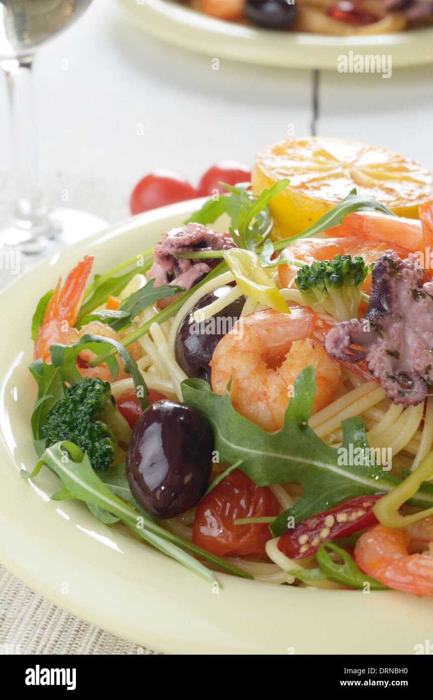 Spaghetti di mare piatto di pasta con il polpo, gamberi, pomodorini e olive  Foto stock - Alamy