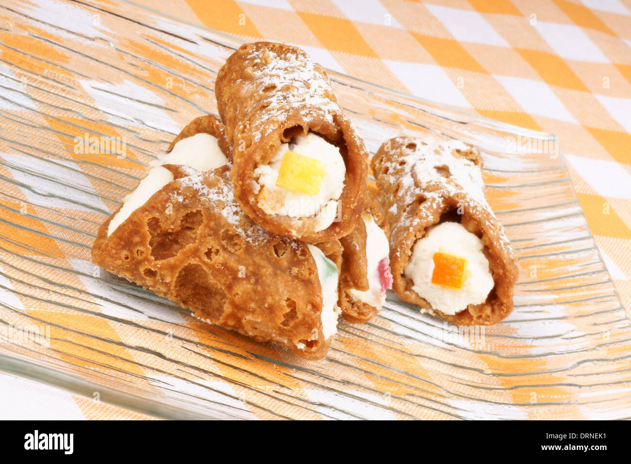 Close-up di originale mini cannoli siciliani su una piastra di colore giallo. Foto Stock