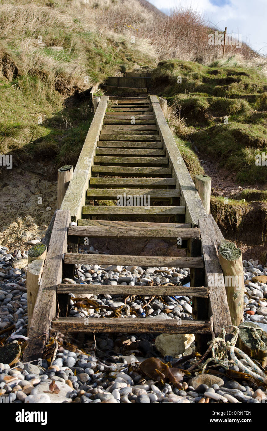 Gradini in legno che conduce ad una spiaggia di ghiaia Foto Stock