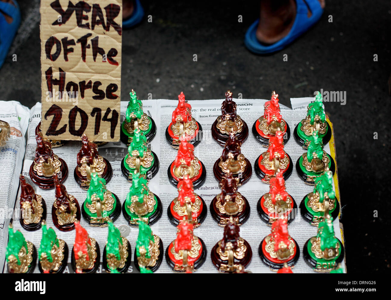 Manila, Filippine. Il 30 gennaio 2014. Portafortuna nella forma di cavalli sono venduti nelle strade Chinatown Manila un giorno prima della celebrazione del Capodanno cinese, l'anno del cavallo il 30 gennaio 2014. Foto di Mark Cristino/Alamy Live News Foto Stock