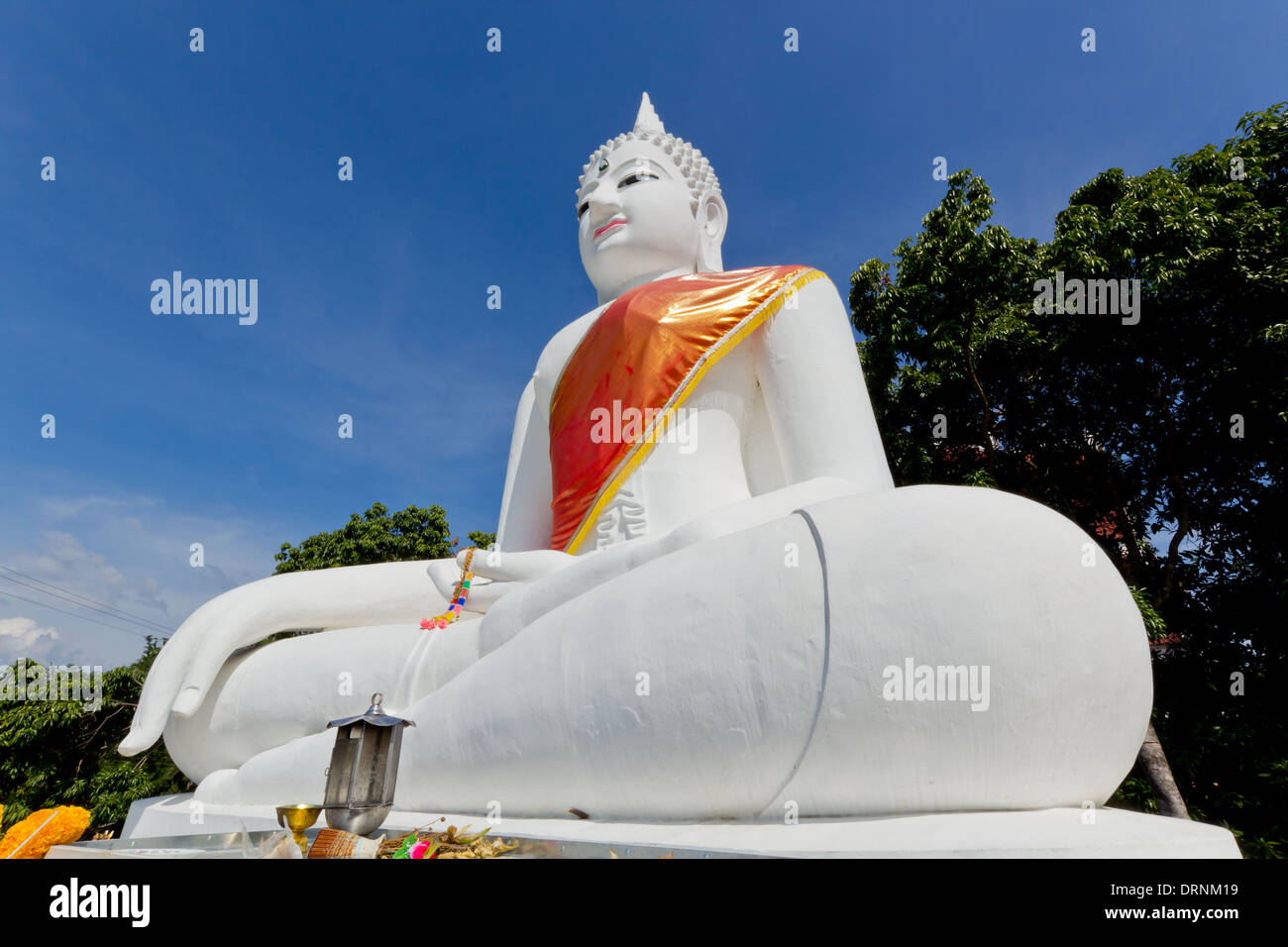 Grande e bianco immagine del Buddha sulla postura di meditazione con cielo blu sullo sfondo Foto Stock