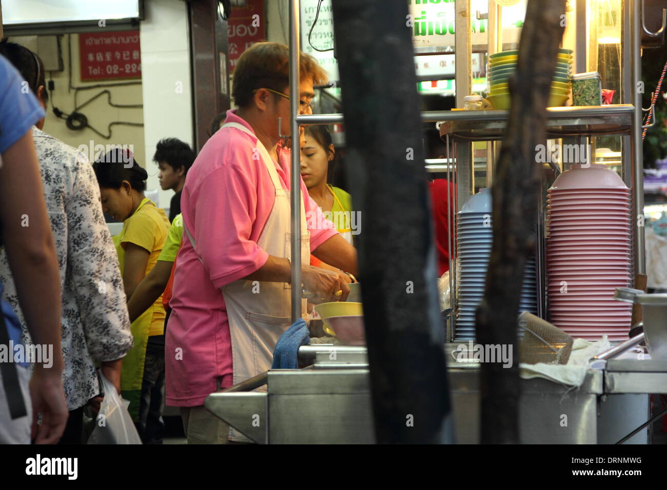 Bangkok , Thailandia 30 gennaio 2014. Commerciante di preparare il cibo per i clienti su una bancarella di strada su Yaowarat rd. Anno Nuovo Cinese celebrare oggi e dare il benvenuto al anno del cavallo . Città ampia le dimostrazioni sono attesi come in Thailandia elezioni generali che si terranno il 2 febbraio è stata avvolta in polemica. Foto Stock