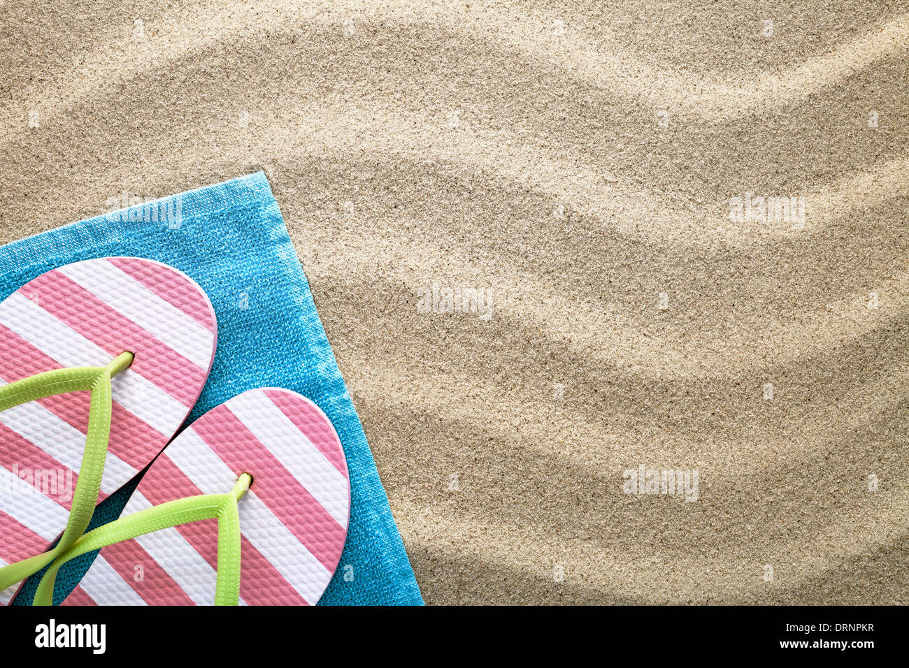 Sfondo di spiaggia con asciugamano e flip flop. Concetto di estate. Vista superiore Foto Stock