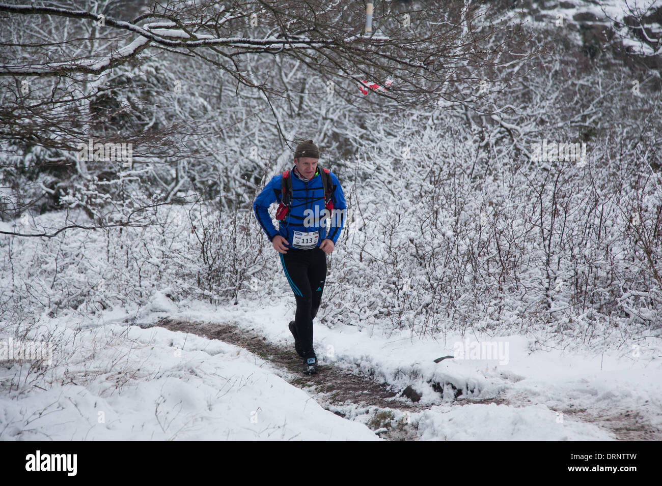 Un runner fa il suo modo fuori del bosco e su per la collina nei pressi di Hammershus. Foto Stock
