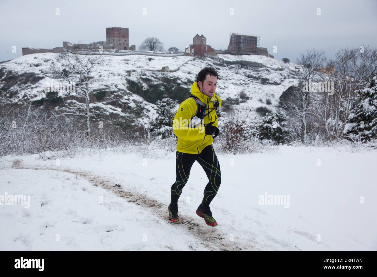 Un runner fa il suo modo sulla collina con Hammershus nel retro di massa. Foto Stock