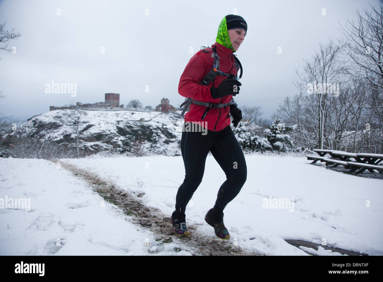 Un runner fa il suo modo sulla collina con Hammershus nel retro di massa. Foto Stock