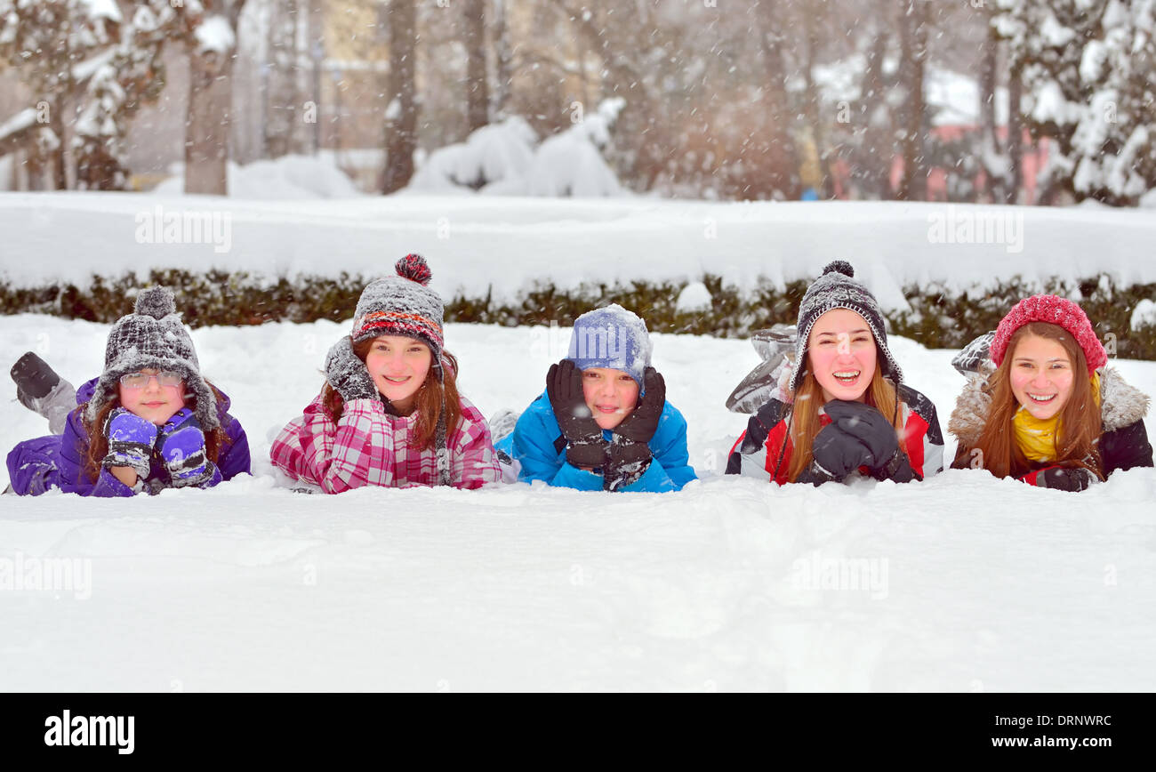 Un gruppo di bambini che giocano sulla neve in inverno Foto Stock
