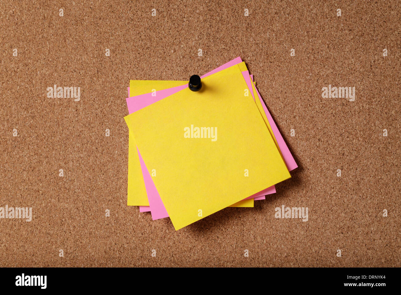 Mazzetto di vuoto sticky notes sulla bacheca di sughero Foto Stock