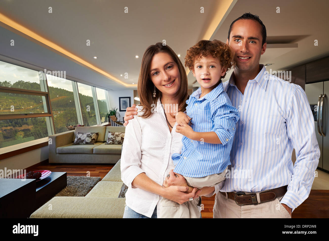 Giovane famiglia felice a casa: madre, padre e figlio Foto Stock