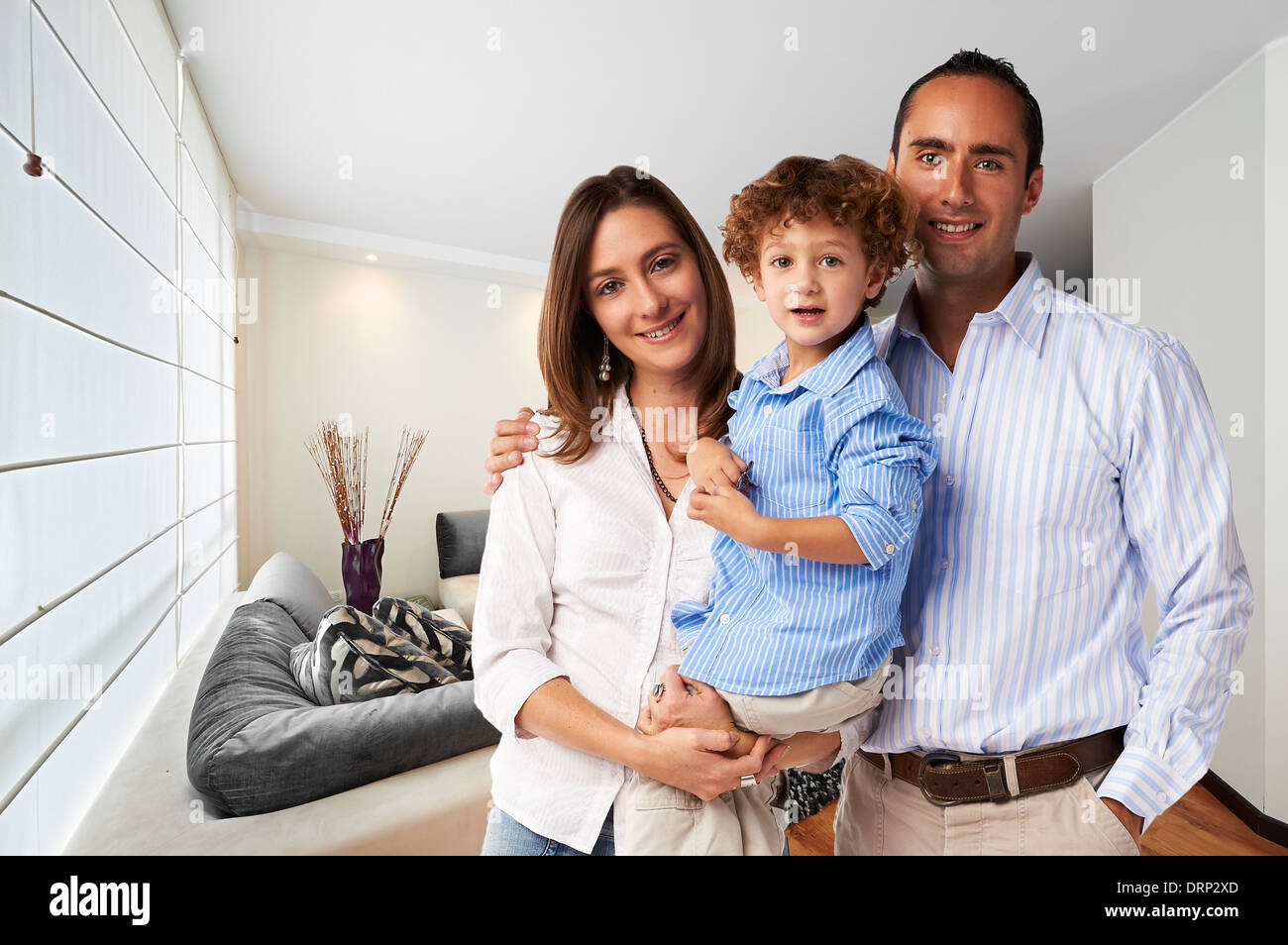 Giovane famiglia felice a casa: madre, padre e figlio Foto Stock