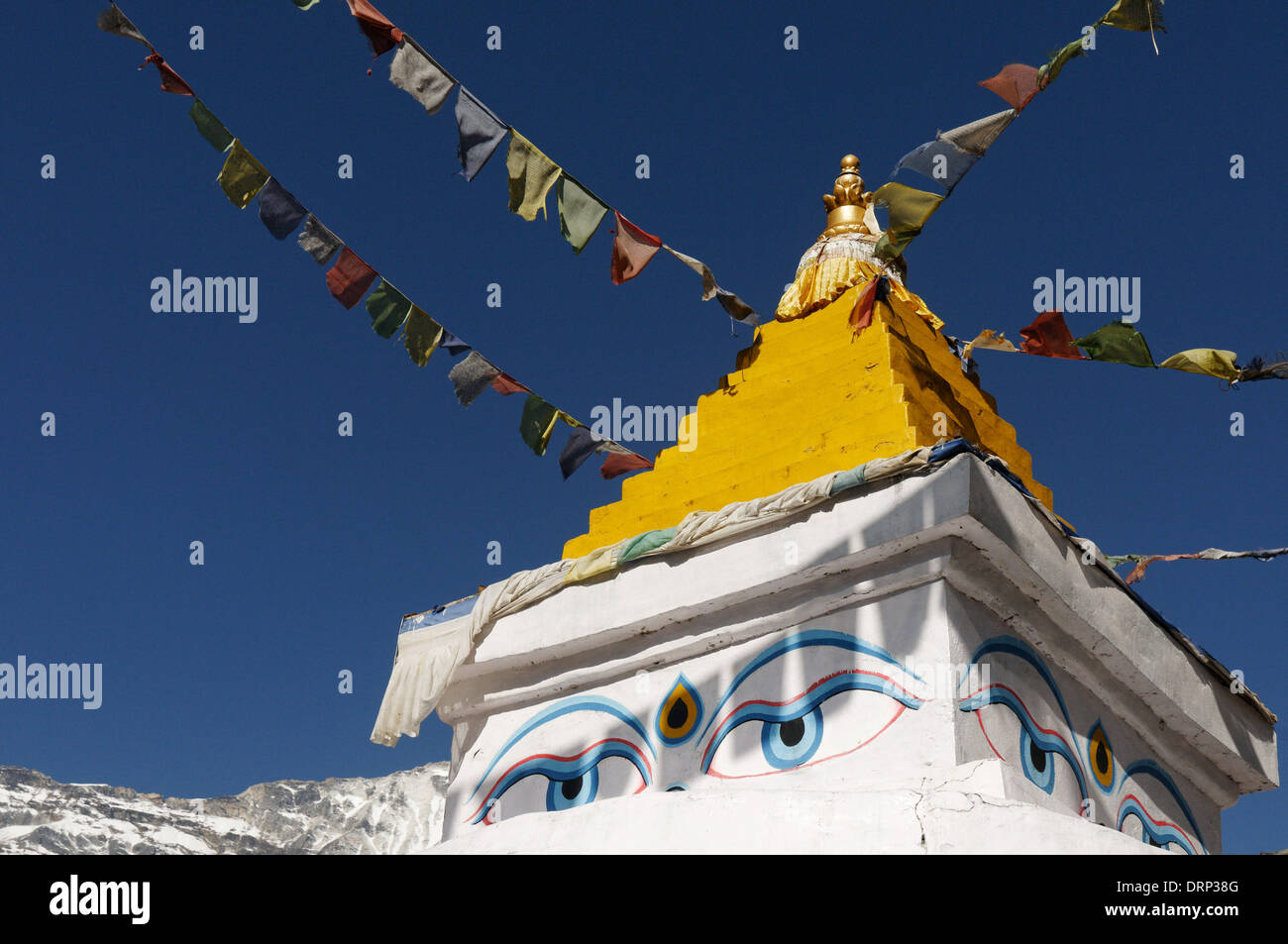 Preghiera di bandiere e di un giallo stupa in Nepal contro un cielo blu chiaro Foto Stock