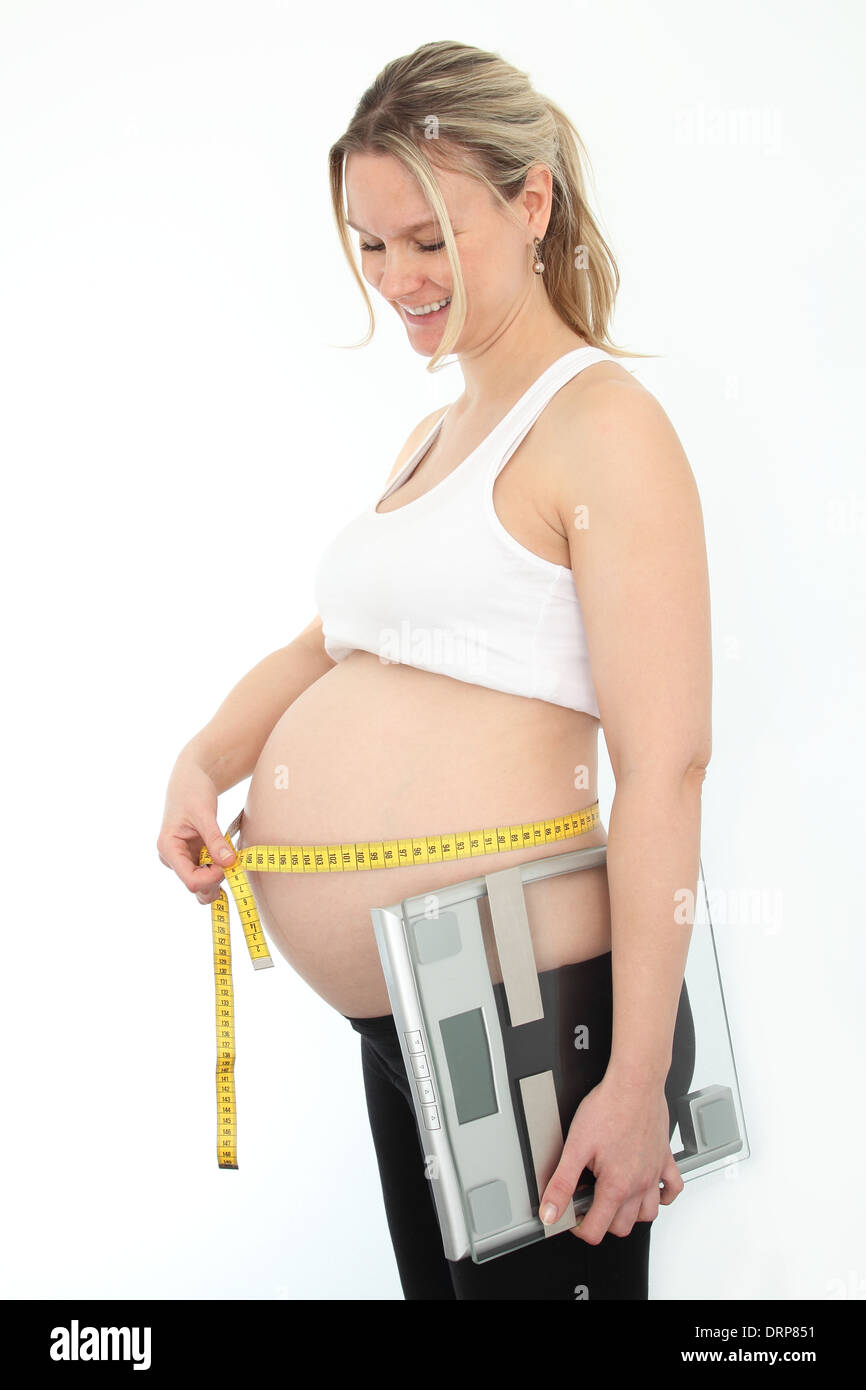 Donna incinta con nastro measering e livello Foto Stock