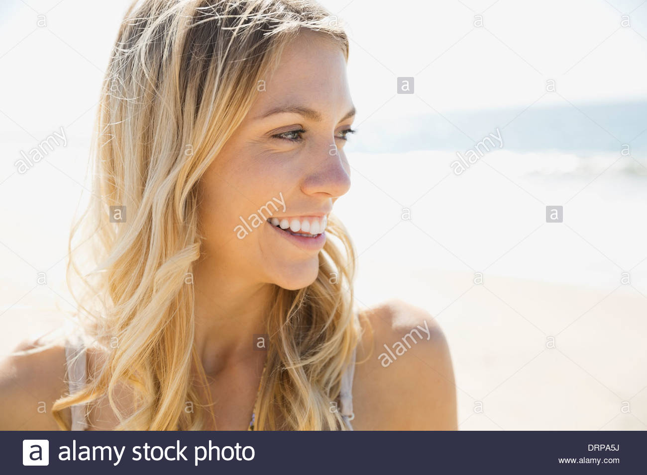 Bella donna sorridente sulla spiaggia Foto Stock
